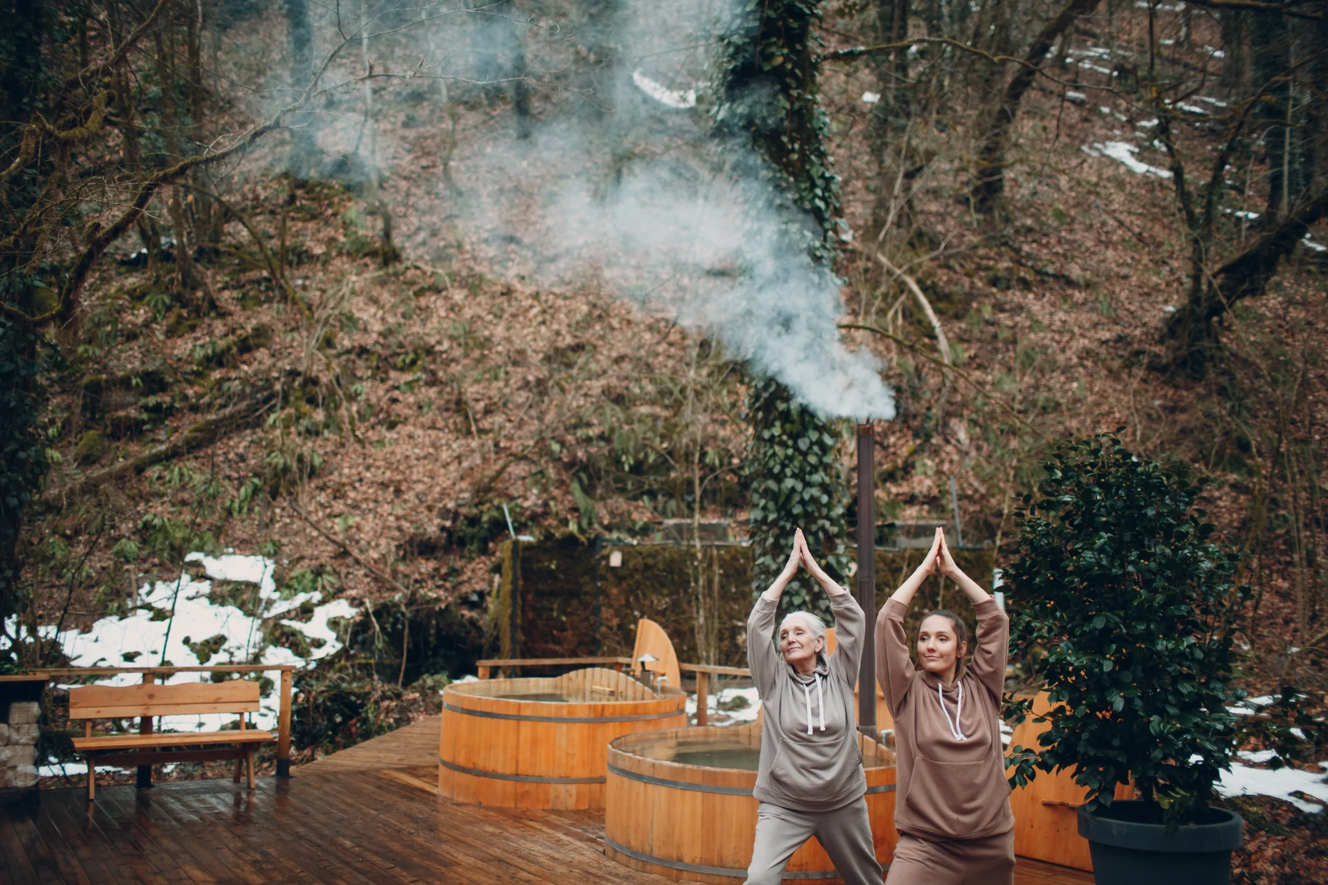 Women doing exercises sports and fitness outdoors Young and senior elderly woman warming up and yoga at glamping Mother and daughter having zen like modern fitness vacation