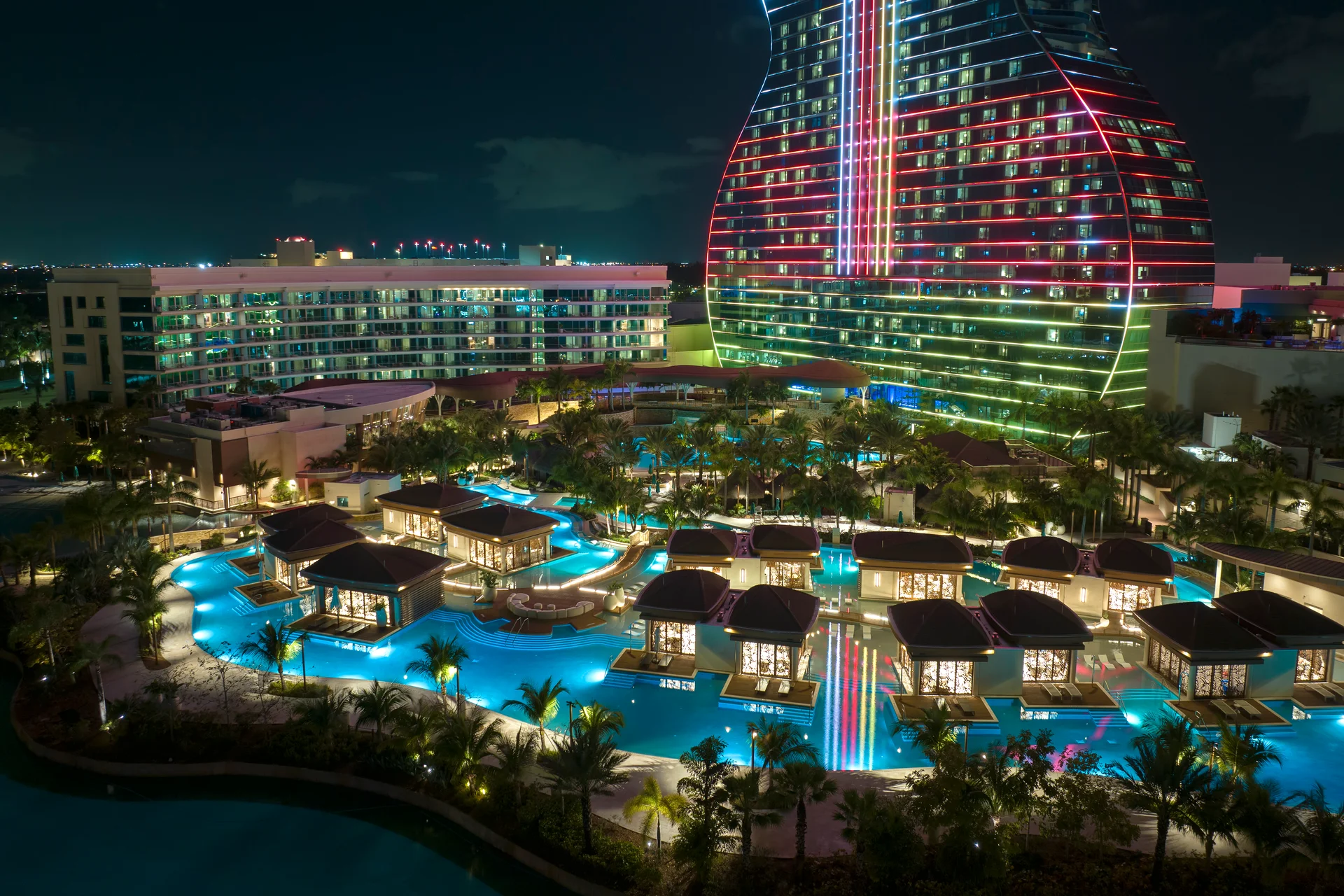 Aerial view of guitar shaped Seminole Hard Rock Hotel and Casino structure illuminated with bright neon colorful lights in Hollywood Florida