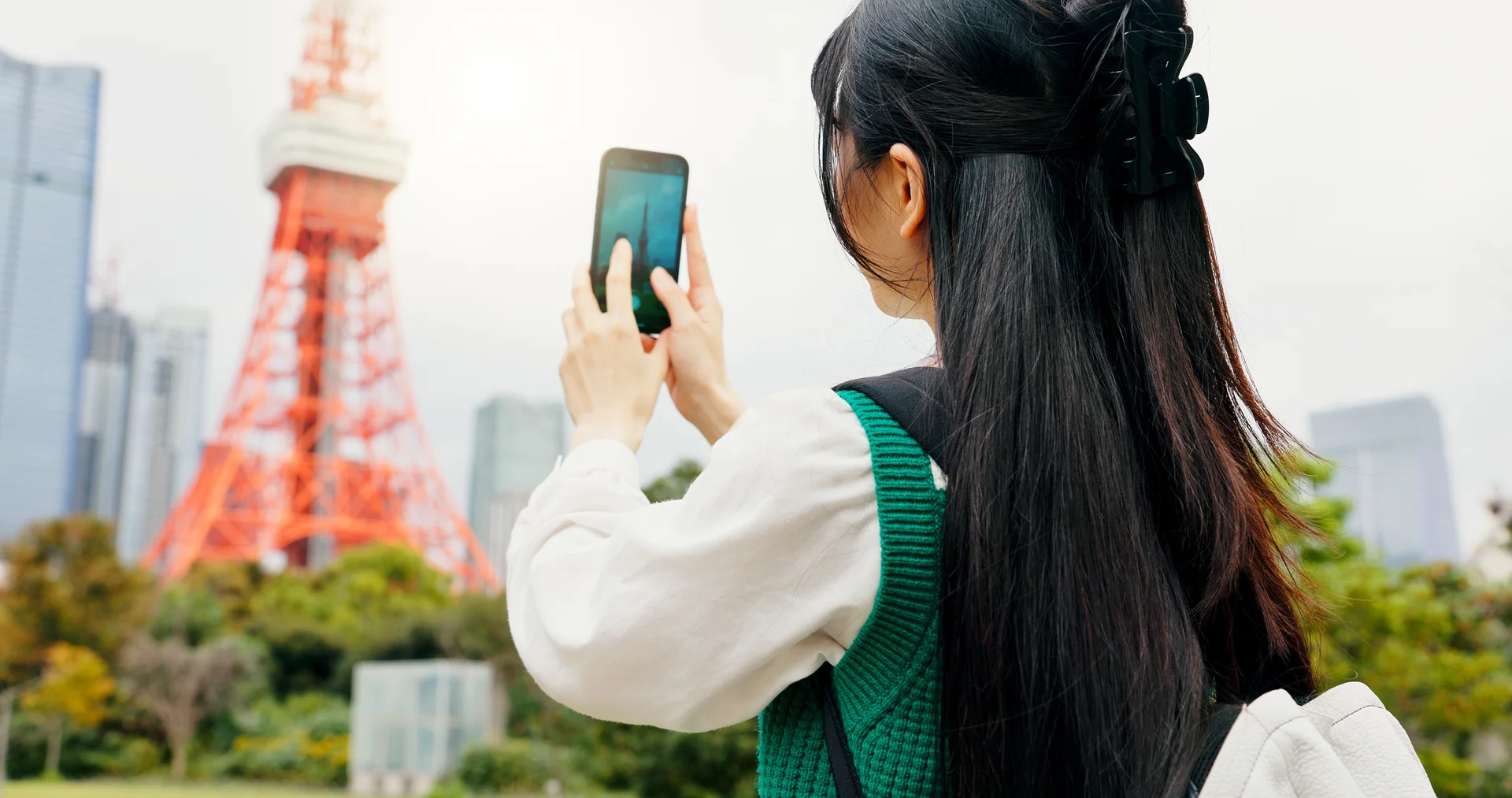 Travel photography and person with smartphone city and capture of landmark screen and content creation Outdoor influencer and tourist with mobile display and picture of Tokyo Tower in Japan