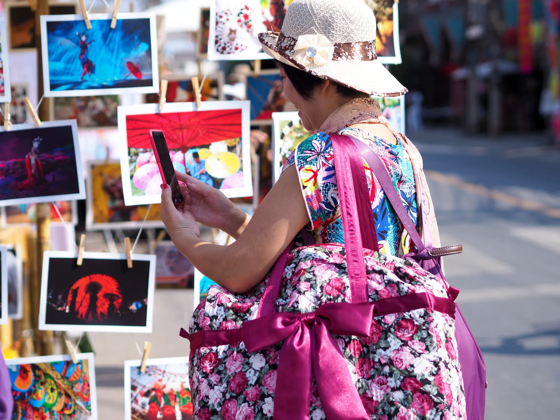 Asian women backpacker looking for are viewing photos of tourist attractions in Thailand tourism festival.