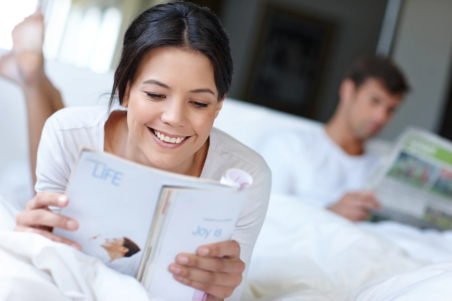 The more you read the more you know Shot of a beautiful woman lying in bed reading a magazine
